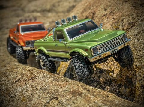 Badass 1/18 Scale RC Crawler With Slick Shifting Two Speed Transmission And Bulletproof Metal Gears Nasty Terrain Rock Climbing Rig Trail Smashin Setup Drop In Ready Convoy Medium Olive Green on rocky terrain.