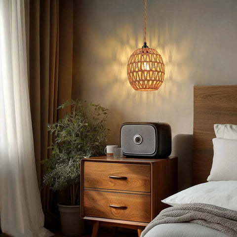 Homebody Essential Plug In Pendant Light Featuring Hand Woven Rattan And Wicker Egg Shade With 15 Ft Cord above a nightstand.
