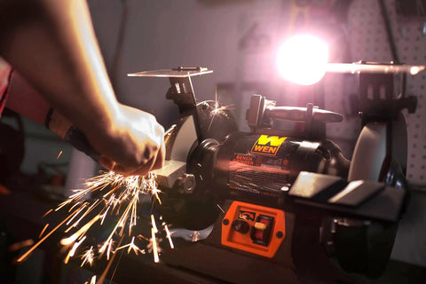 Rock Hard Bench Grinder With Eight Inch Grinding Wheels and a Snappy Variable Speed Motor sharpening metal, sparks flying.