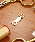 Gold Zipper Pull Replacement For Luggage Backpack Jacket Suitcase Coat Easy Slider Repair With Zipper Tab Fasteners on table
