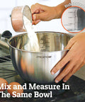 Pouring flour into stainless steel mixing bowl with etched measurements, part of Stainless Steel Mixing Bowls With Lids Set Featuring Airtight Lids And Non Slip Base, Five Nesting Bowls In 1.5 Qt, 2 Qt, 3 Qt, 4 Qt, And 5 Qt For Big Prep, Thick Durable Metal, Lifetime Durability, Dishwasher Safe Kitchen Essentials.