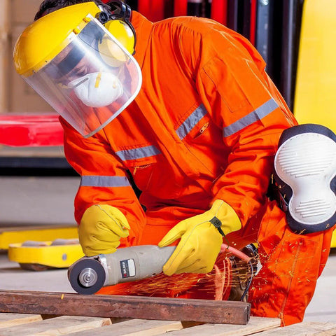 Worker uses angle grinder wearing Rugged Leather Work Gloves For Men And Women, Cowhide Build That Holds Up To Real Work, in orange suit.