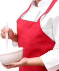 Chef wearing red bib apron from Bulk Pack Bib Aprons For Restaurant Pros, 12 Pack, Long Oversized Unisex Kitchen Aprons, 20 By 20 Inches