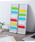 Solid As A Rock Wall Mount Id Card Holder Rack Featuring 28 Spacious Openings Crafted From Bump Resistant Polymer Plastic For Tight Cluttered Offices Warehouses And Clock In Areas on a desk with colorful ID slots.