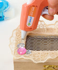 Using Clear Mini Hot Glue Sticks 4 Inch, 550 Count, All Temp Bonding for Crafting on a wooden box with lace and jewels