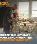Person using Centipede 30 Inch Folding Work Table Set No Assembly With 9 Struts Collapsible Frame 3500 Lb Capacity