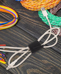Reusable Black Polyester Cable Ties For Desk Wire Management Heavy Duty Cord Straps For Computer Setup Electronic Organizer securing loose USB cable on wooden surface.