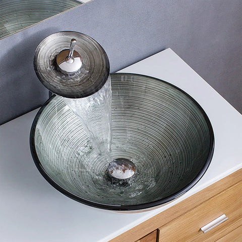 USZWBY Tempered Glass Bathroom Vessel Sink, Round Shape Spiral Pattern with waterfall faucet and pop up drain in use.