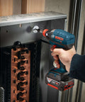 Side view of Bosch cordless impact driver with Phillips #2 bit installed, driving into a copper electrical panel.