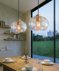 CASAMOTION Glass Pendant Lights, Textured Clear Globe Shade above a dining table in a modern setting.