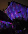 Motion Pattern Firefly 3 In 1 RGB Outdoor Laser Christmas Lights Projector With 18 Moving Patterns illuminating a house facade