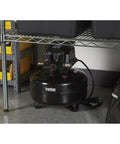 Portable 3 Gallon Air Compressor 0.3 HP 110 PSI Max Pressure Oil Free Pump under a shelf, black steel drum with handles.