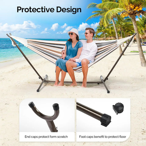 Two people sitting on a hammock supported by a 550 Lbs Capacity Hammock Stand With Portable Carrying Bag Heavy Duty Two Person Frame For Outdoors And Indoors Black Antique Finish Sturdy Steel Construction on a beach.