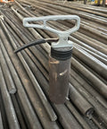 MUTUACTOR magnetic pickup tool with release handle; grey handle, black magnet housing, resting on steel rods.