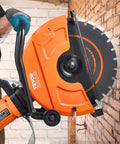 Heavy Duty Electric Concrete Saw With 16 Inch Circular Blade And A 3200 Watt Motor delivering wet cuts against a brick wall.