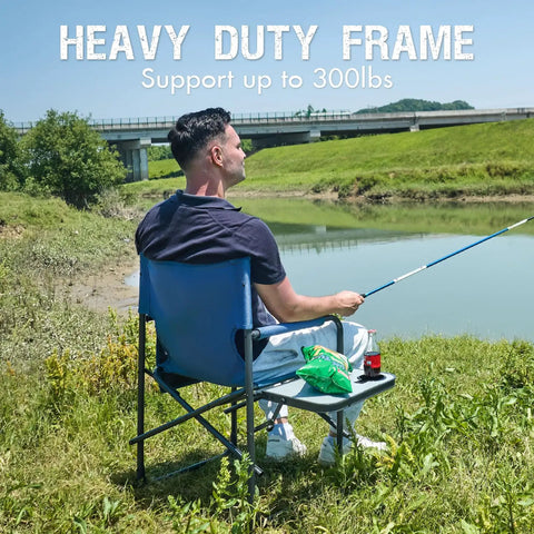 Man fishing seated on Directors Chair For Outdoors With Side Table Foldable Camping Chair For Adults, blue grey, by a lake.