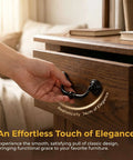 A hand pulling a drawer with a Four Pack Antique Drawer Pulls In Black Finish, Vintage Brass Look Cabinet Knob on wooden dresser