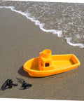 Two Pack CNC Model Ship Propellers For RC Boats next to yellow toy boat on sandy beach, showcasing precision balanced blades.