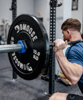 Man using barbell with Two Inch Quick Release Barbell Clips With Anti Slip Lining For Easy On Easy Off Secure Weightlifting