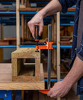 Person using Beefy 12 Inch Opening Heavy Duty Steel Bar Clamp With Protective Pads Orange for woodworking project