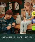 Man holding a sample of One Layer Wood Stain and Finish in Bourbon Color Oil Plus 2C, child sitting on wood planks.