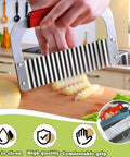 Front view of extra-large stainless steel crinkle cutter with wooden handle slicing potatoes on a cutting board.
