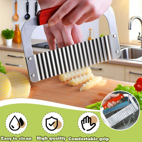 Front view of extra-large stainless steel crinkle cutter with wooden handle slicing potatoes on a cutting board.