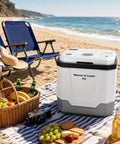 Heavy Duty 35 QT Portable Electric Cooler And Warmer For Cars Trucks And Homes 12V 110V Thermoelectric Fridge Box With Power Cord Gray on beach with picnic setup.