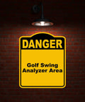 Golf Swing Danger Area Sign In Yellow And Black Aluminum Composite Construction Rust Resistant Weatherproof Pro Grade Warning Plate For Golf Practice Range against a brick wall.