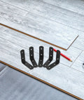 Heavy Duty Black Stainless Steel L Shaped Right Angle Brackets For Shelves Cabinets And Furniture Support on wooden floor
