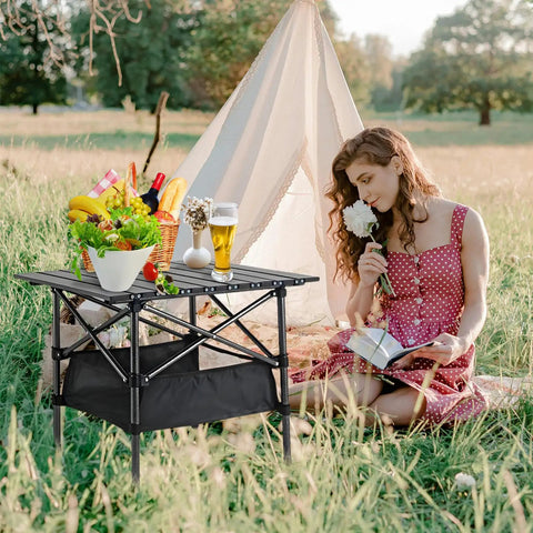 Foldable Aluminum Beach Table For Camping And Outdoors Ultra Lightweight And Rust Resistant Easy Fold And Unfold In Seconds 20 X 20 Inch Portable Camp Table With Storage Bag Ideal For Picnics Beaches Hiking And Grilling shown near woman in park