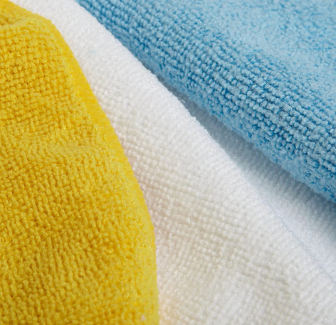 Microfiber cleaning cloths; blue, white, and yellow; close-up fabric texture