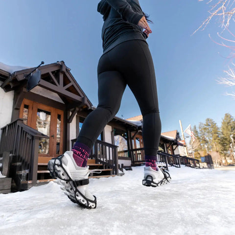 Heavy Duty Tungsten Carbide Spikes For Ice Walkers Large X Large Black Traction Cleats on snowy sidewalk under sunny sky.