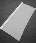 Nonstick PTFE Film Roll For Heat Press Transfers And Craft Projects, white sheet unrolled on textured background, reusable heat mat sheet