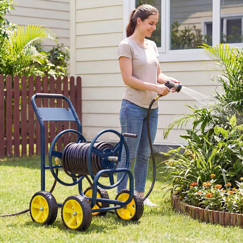 Woman using must have heavy duty garden hose reel cart with four solid wheels mobile water hose cart that holds up to 330 ft of 5/8 inch hoses durable metal frame easy maneuver for lawn and backyard navy blue