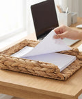 Hand placing papers in Water Hyacinth Paper Tray Organizer 3 Piece Desk Set For Home Office Open Front Mail Sorting Trays Active File Storage