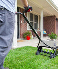 Person using 20 Inch Premium Push Spike Aerator With 3D Galvanized Steel Tines And Weight Tray For Deep Core Penetration on lawn