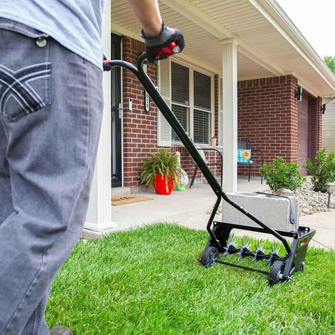 Person using 20 Inch Premium Push Spike Aerator With 3D Galvanized Steel Tines And Weight Tray For Deep Core Penetration on lawn