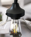 Close-up of Rain Drop Table Lamp With Dope Glass Shade In Warm Bronze Finish, showcasing bulb and design details.