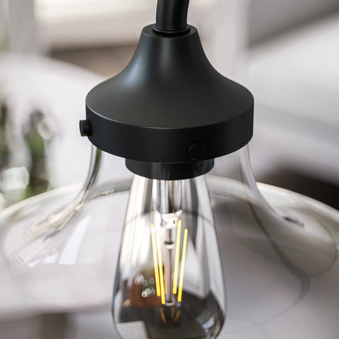 Close-up of Rain Drop Table Lamp With Dope Glass Shade In Warm Bronze Finish, showcasing bulb and design details.