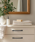 30 Pack 5 Inch Hole Center Kitchen Cabinet Handles Curved Black Zinc Alloy Drawer Pulls installed on ivory dresser