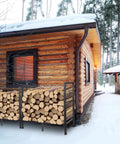 Built Tough Heavy Duty Firewood Rack For Indoor And Outdoor Use 2ft Log Storage Holder beside cabin in snowy setting