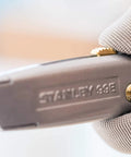 Close-up of silver everyday utility knife with retractable blade for safe precise cutting in DIY projects, showing non-slip handle detail.