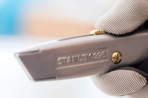 Close-up of silver everyday utility knife with retractable blade for safe precise cutting in DIY projects, showing non-slip handle detail.