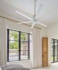 White 84 Inch Smart Outdoor Ceiling Fan delivering killer cooling power in a bright room with large windows.
