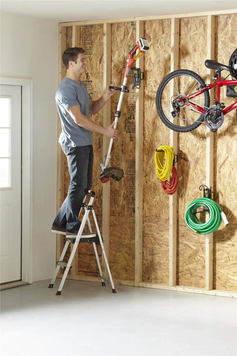Man standing on Lite Folding Step Stool With Extra Large Slip Resistant Platform, Aircraft Grade Aluminum Build, Non Marring Feet, Easy Fold System For Flat Storage, Game Changing Home Helper For Reaching High Cabinets And Shelves, reaching garage wall storage