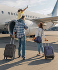 Two 20-inch expandable carry-on suitcases with spinner wheels, black and blue, on an airport tarmac beside a family.