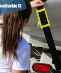 Person attaching 2 Inch Ratchet Strap Protectors For Trailer Tie Downs to boat, showing protective sleeve on strap