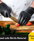 Chef wearing 8 Mil Disposable Nitrile Gloves With Diamond Textured Grip 100 Count cutting tomatoes on wooden board.