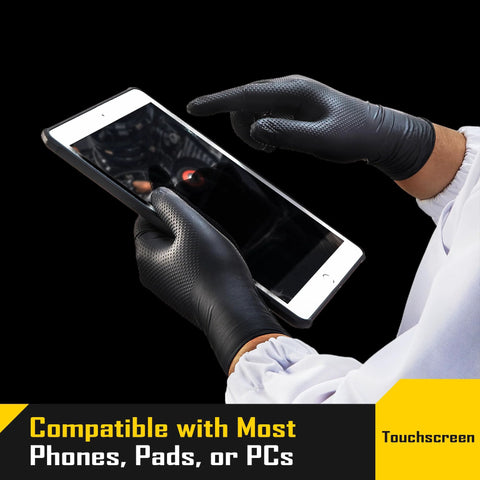 Person using tablet with 8 Mil Nitrile Gloves With Diamond Grip For Mechanic Work And Cleaning 100 Ct. touchscreen capability